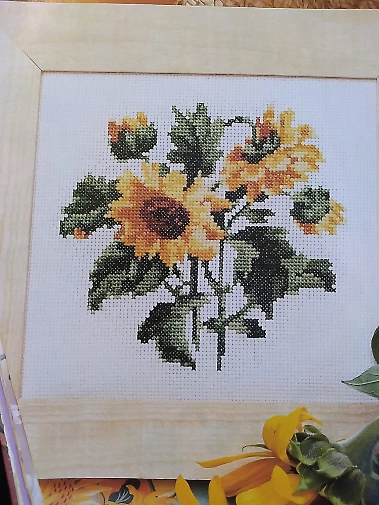 Cross stitch pattern: colorful sunflower and mixed floral bouquet on white fabric