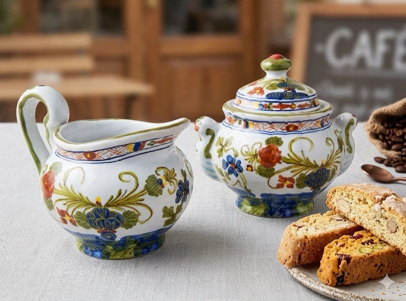 Floral ceramic creamer and lidded sugar bowl set, white with blue accents and lid