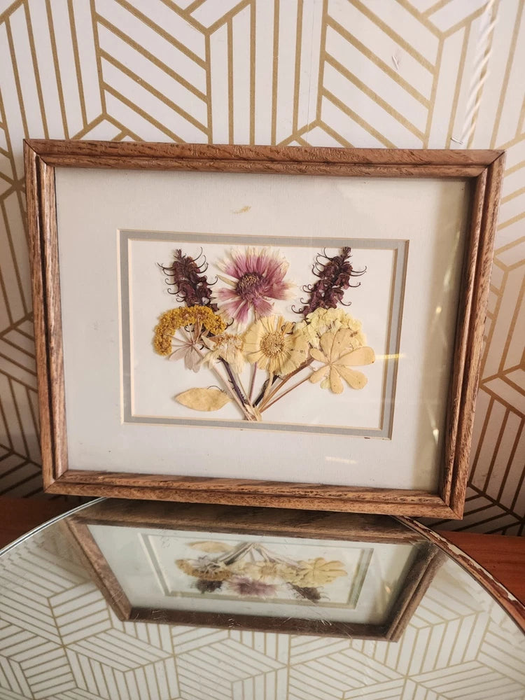 Framed dried pressed wildflower arrangement with mixed blooms in a wooden frame and mat