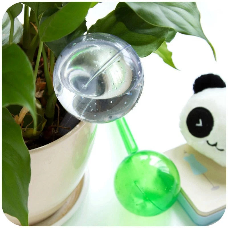 Automatic plant watering globe with clear bulb and green suction tube