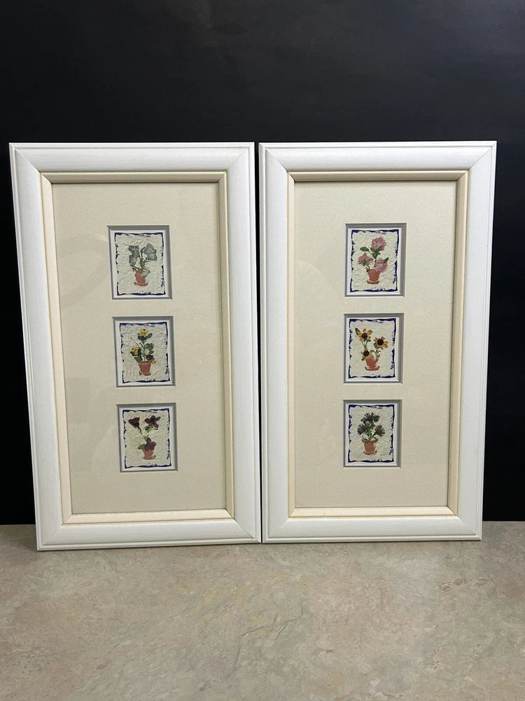 Set of 2 framed dried pressed-flower prints with three small floral designs each.