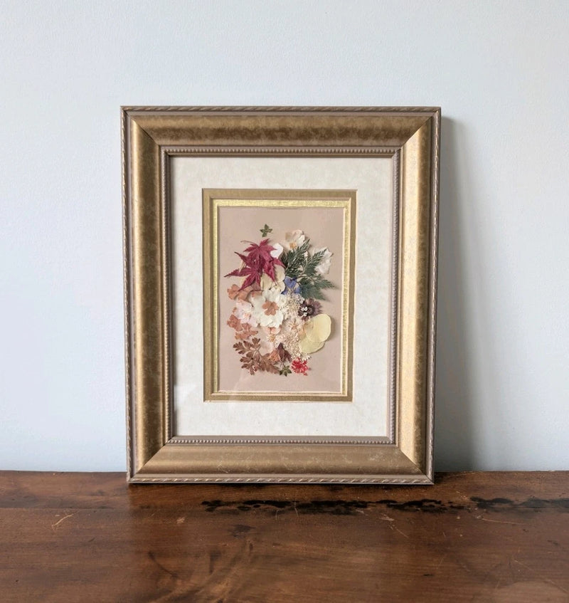 Framed pressed flower botanical wall art with gold-toned rectangular frame
