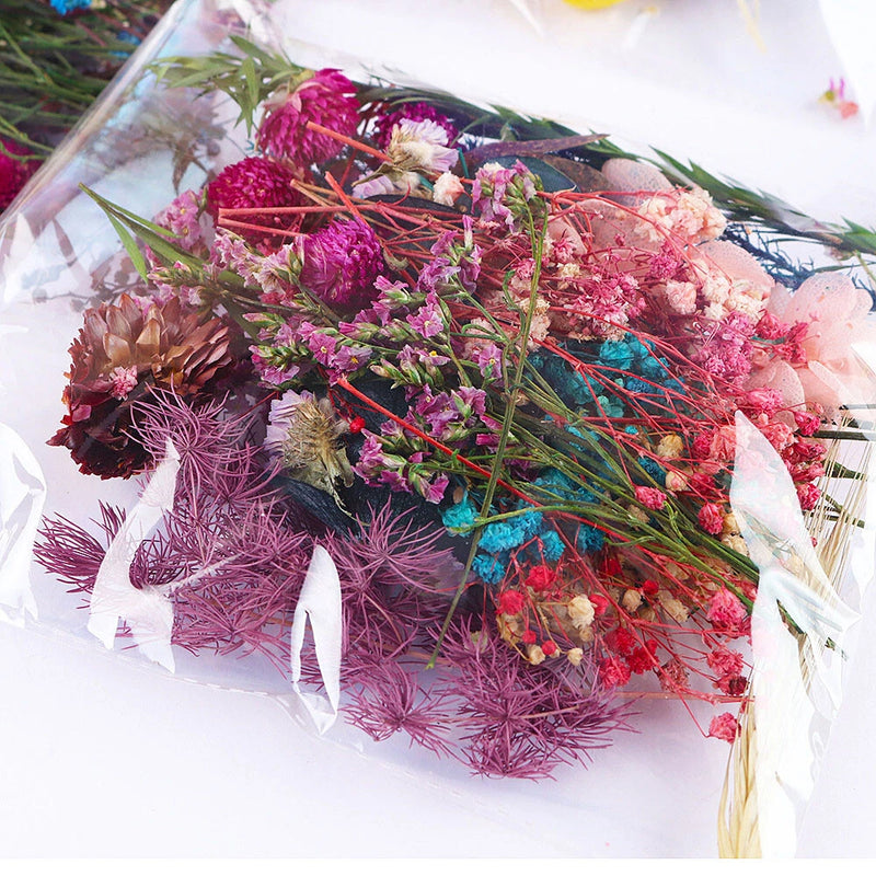 Mixed dried flower bundle with pink, purple, and blue blooms and thin stems