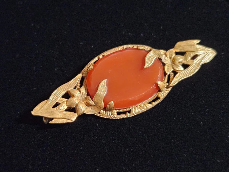 Gold-tone Art Nouveau lily brooch with red oval carnelian center and leaf detailing