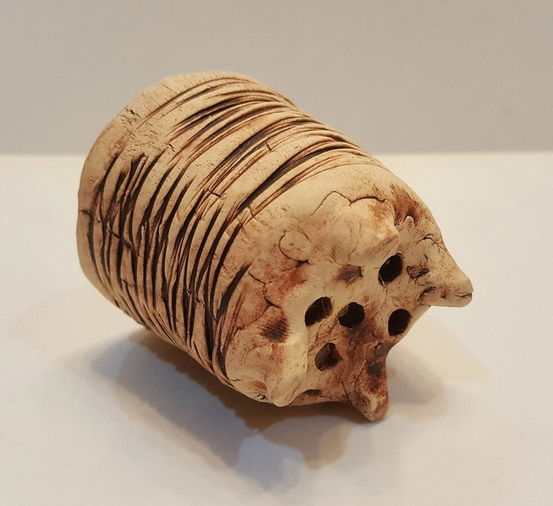 Ceramic hedgehog-shaped planter with carved stripes and dark spots