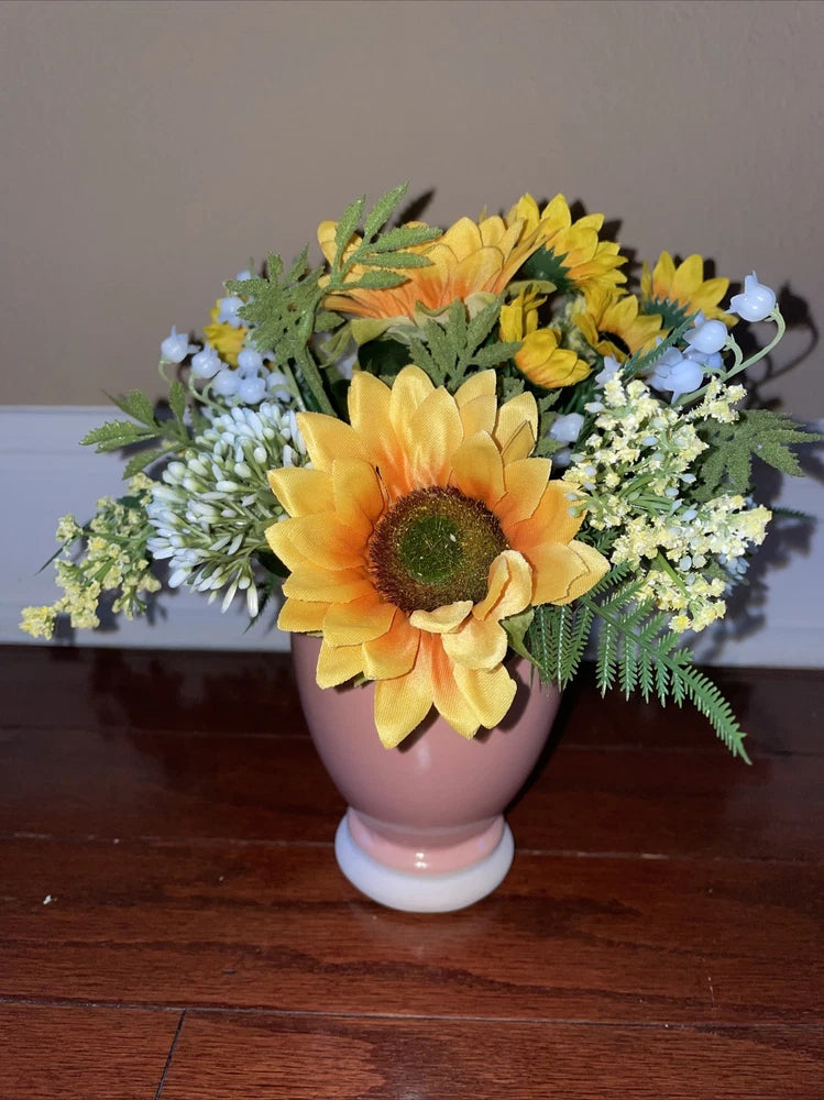 Small silk sunflower flower arrangement in pink ceramic vase with yellow blooms and greenery