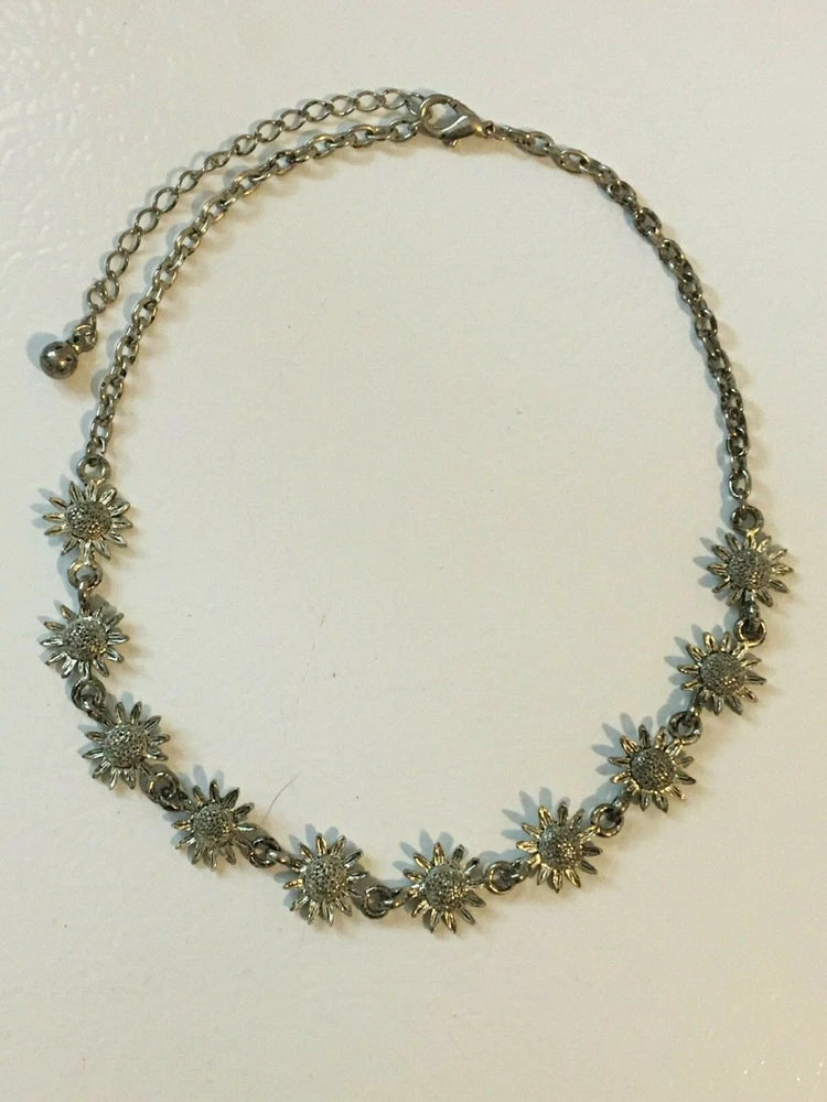 Silver tone chain necklace with tiny sunflower charms in a round wreath