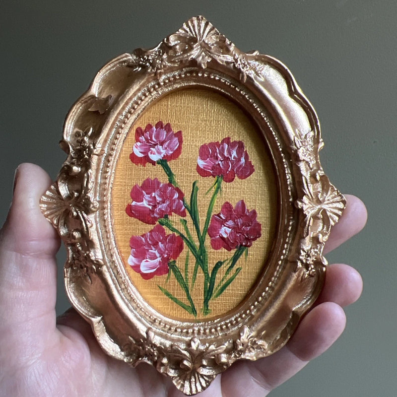 Mini framed carnation flower painting with purple and red blossoms in ornate gold oval frame