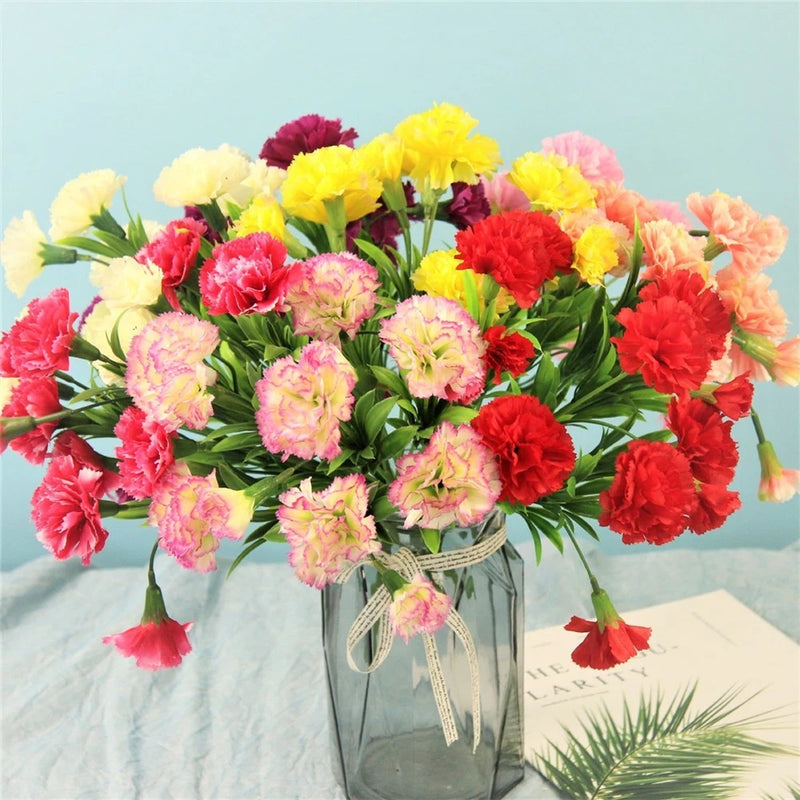 Artificial carnation bouquet with multicolor blooms in clear glass vase, tied ribbon