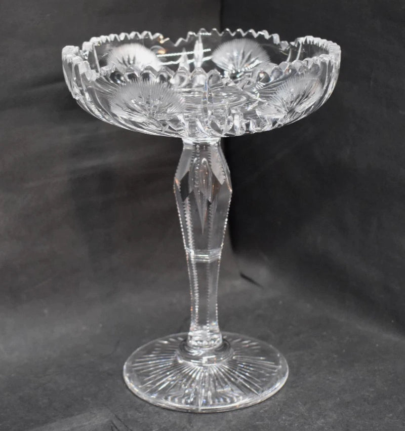 Antique cut-glass compote with scalloped bowl and ornate floral pattern on pedestal base