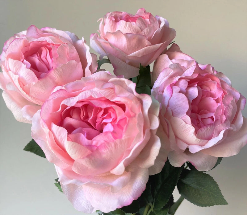 Pink artificial rose stem with multiple spring flowers and green leaves