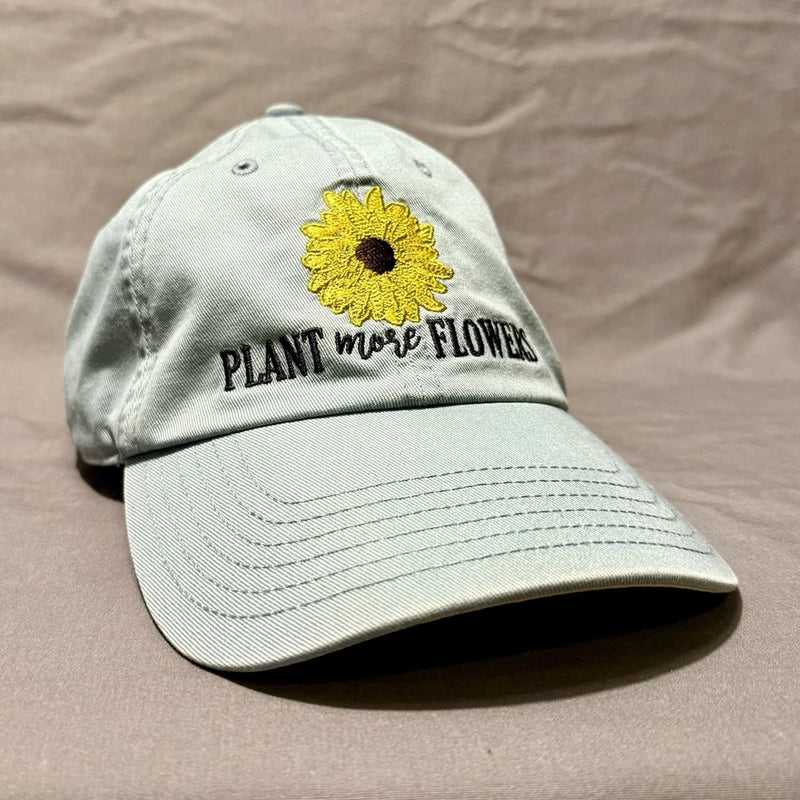Light gray dad hat with yellow sunflower patch and "PLANT MORE FLOWER" text