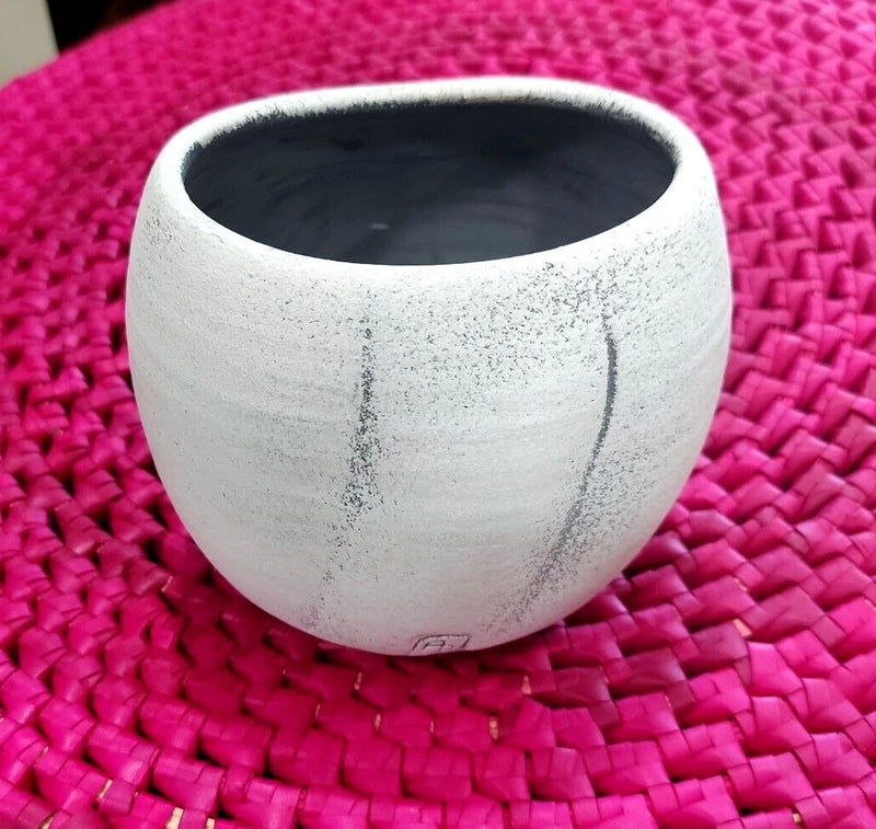 Handmade round earthenware plant pot with speckled white finish and dark interior