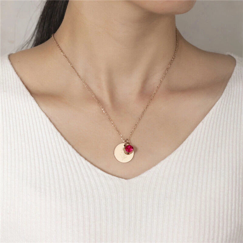Dainty gold-tone necklace with small round pendant and red gemstone