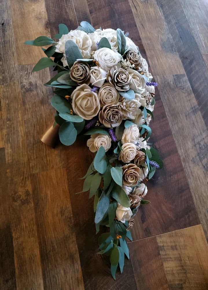Cascading bridal bouquet with cream and tan sola wood flowers, blue accents, eucalyptus leaves