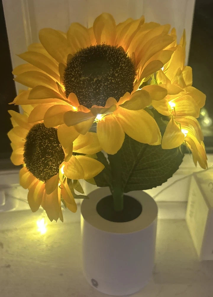 Yellow sunflower LED light decoration with twinkling string lights on a white base