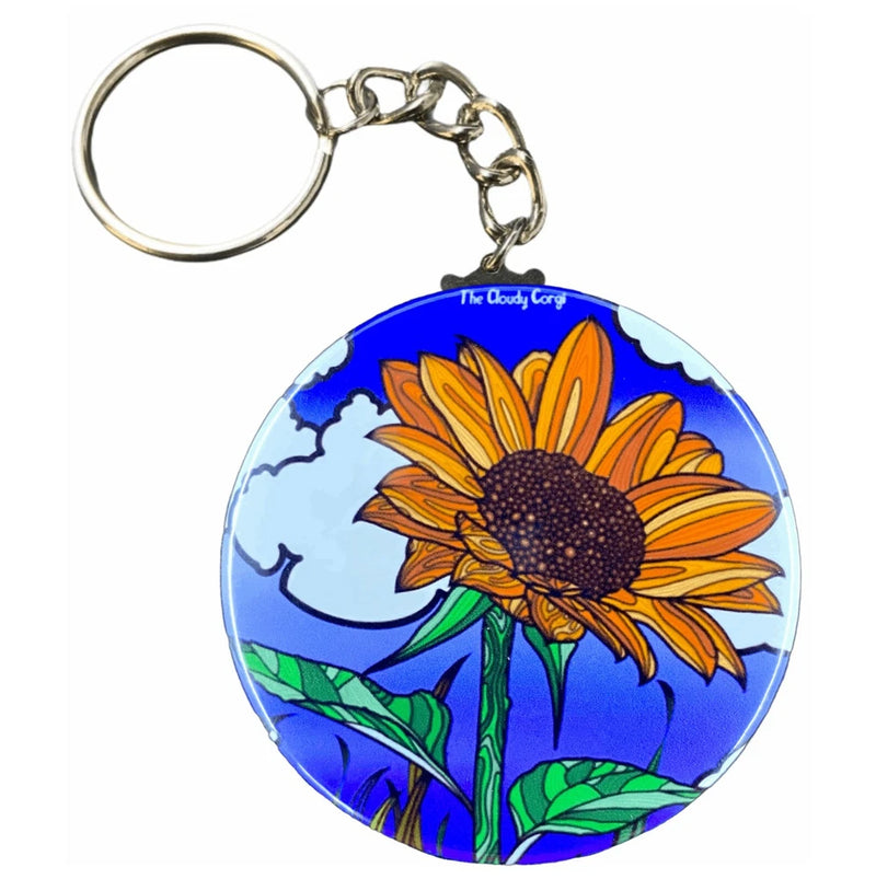 Round key ring with colorful sunflower, clouds, and "The Cloudy Corg" graphic