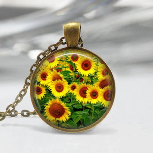 Sunflower pendant necklace with round cabochon showing bright yellow flowers on gold-tone chain
