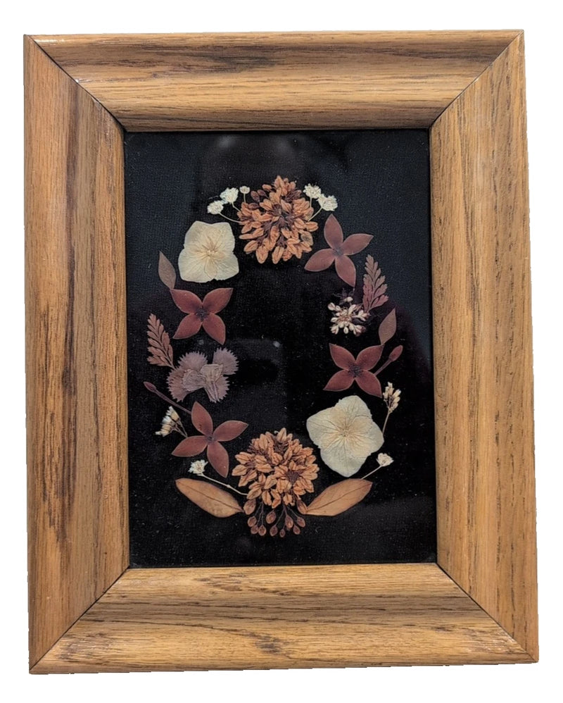 Wood-framed rectangle pressed flower picture with glass, dried blooms on dark background