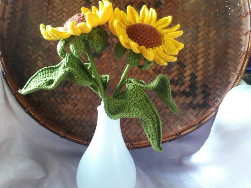Handmade crochet sunflower bouquet with two yellow blooms and green leaves on stems