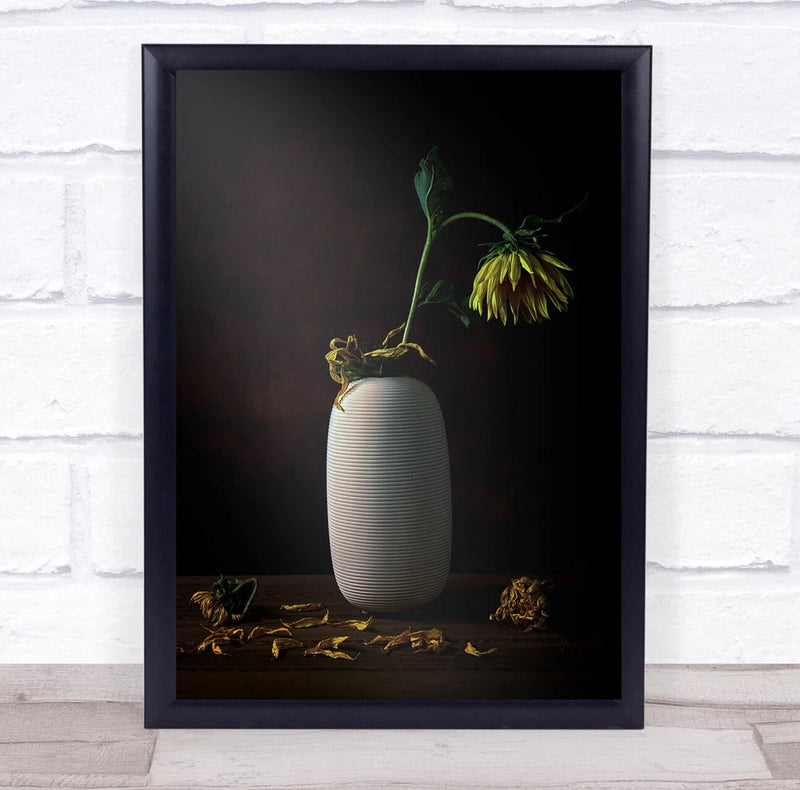 Framed wall art print with white ribbed vase and wilted sunflower stems