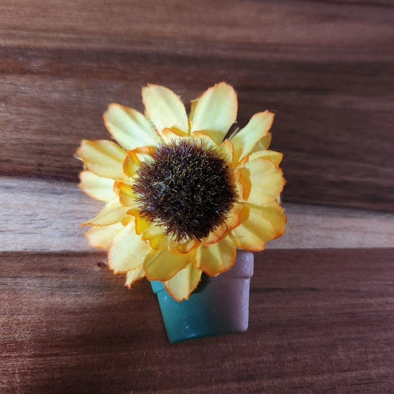 Yellow sunflower floral brooch pin with dark textured center and layered petals