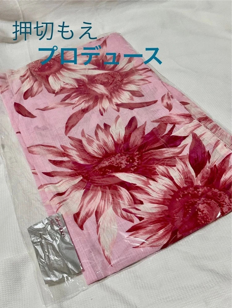 Pink yukata with large red floral/sunflower print, folded