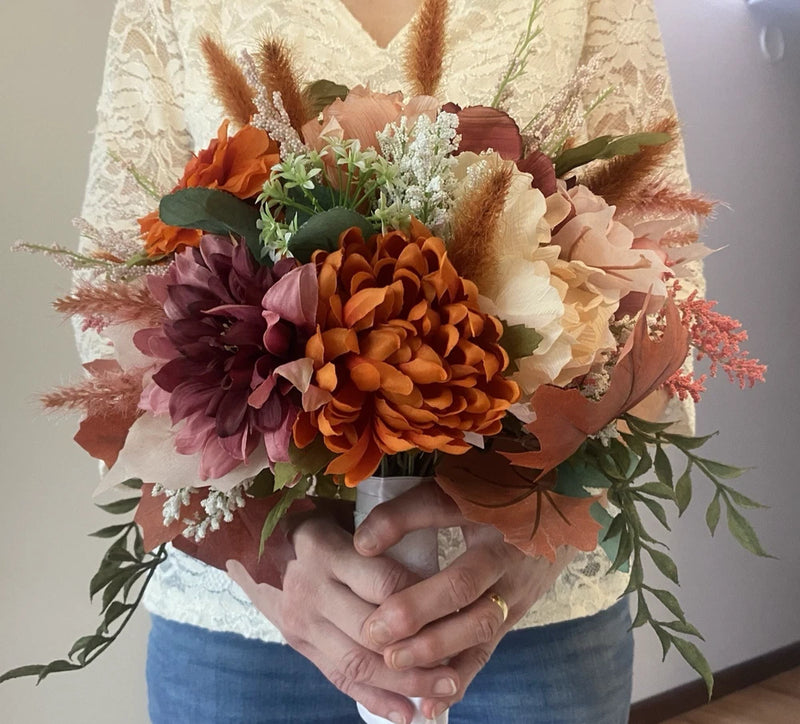 Handmade faux floral bridal bouquet with orange, purple, pink blooms and green leaves