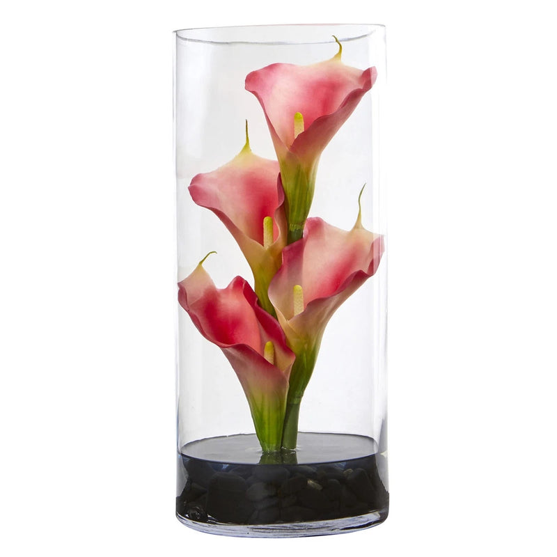 Pink artificial calla lily arrangement in clear glass cylinder with dark base