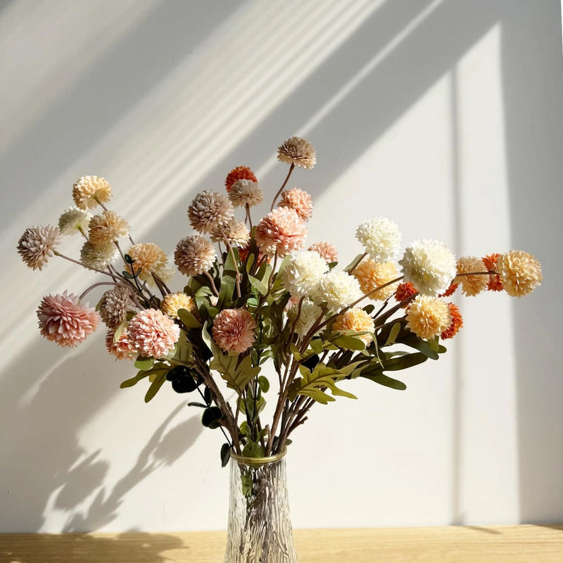 Faux mixed-color kiku flower bouquet with many flower heads on branching stems in vase