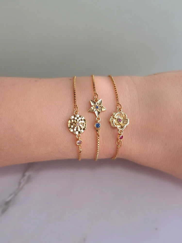 Dainty gold-plated bracelet with birth flower charm and small blue gemstone accents