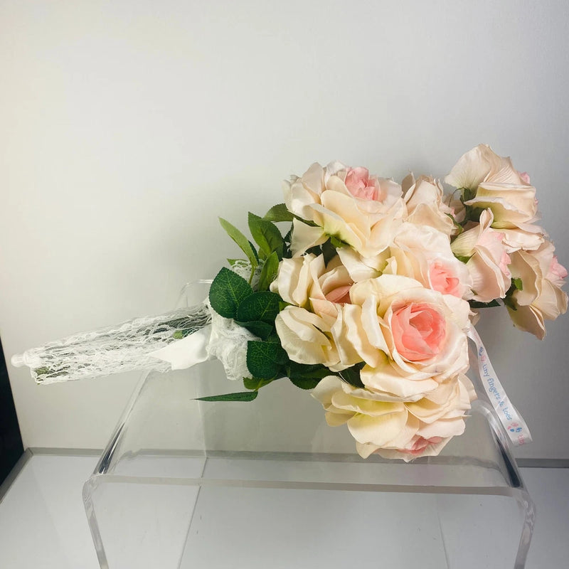 Handheld rose bouquet with cream, blush, and pink artificial flowers and lace ribbon handle