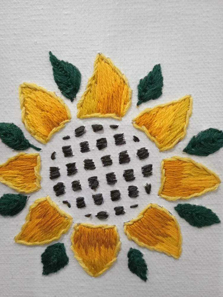 Sunflower embroidery wall art on canvas with yellow petals and green leaves