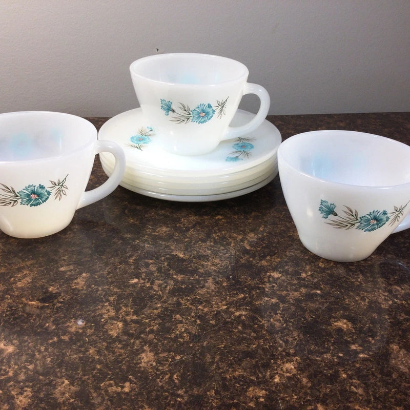 White ceramic coffee cup and saucer set with blue floral pattern