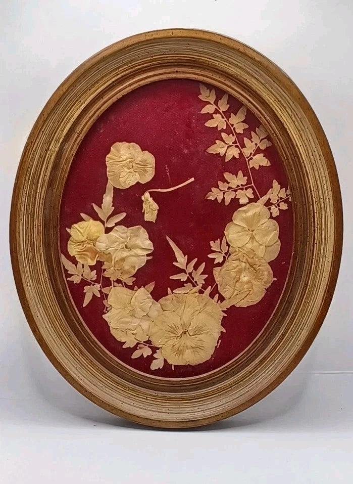 Vintage oval floral wall hanging with dried flowers in wood frame, maroon backing