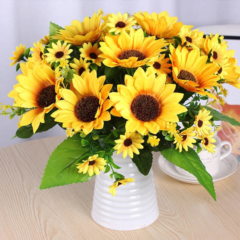 Artificial sunflower bouquet with yellow blossoms and green leaves in white vase