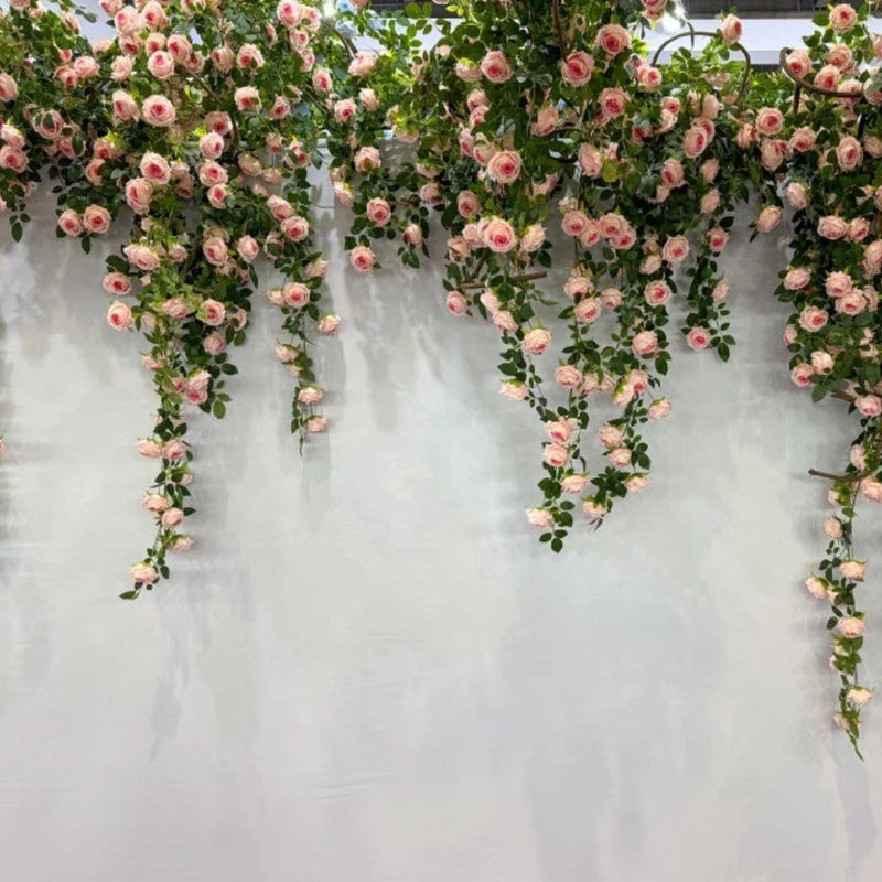 Faux rose vine garland with cascading small pink flowers and green leaves