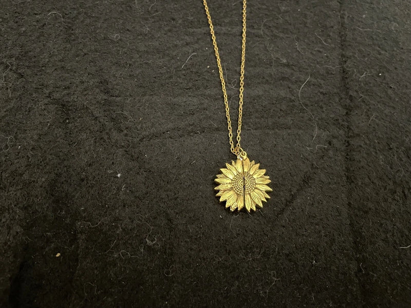 Gold-tone sunflower pendant necklace with delicate chain and round textured flower charm