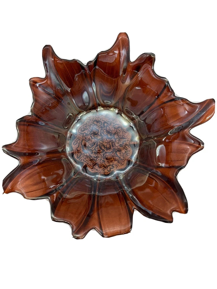 Dark amber carnival glass sunflower bowl with ruffled petals and central embossed medallion