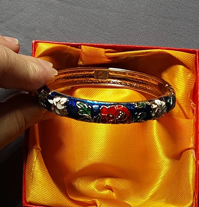 Colorful enamel flower bangle bracelet with peony-style petals and leaves on dark base