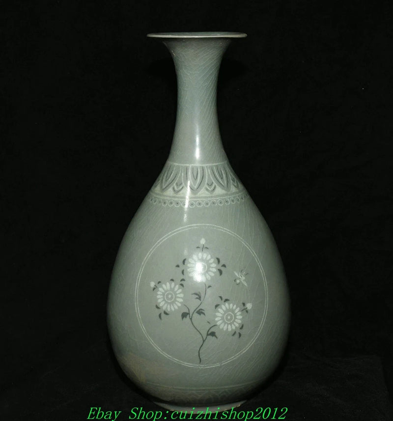 Light blue ceramic bottle vase with narrow neck and engraved floral design.