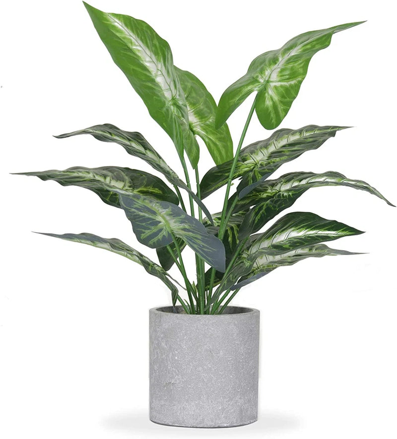 Artificial tropical faux plant with broad green leaves in gray pot