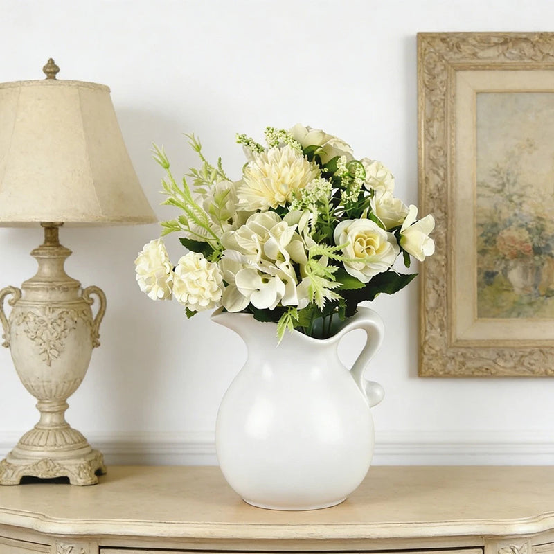 White bridal bouquet of roses and mixed flowers in a white vase
