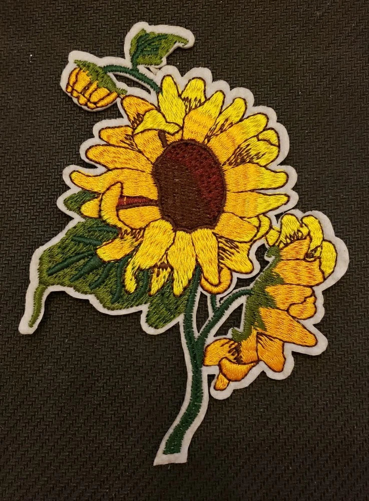 Sunflower embroidered patch with yellow petals, brown center, green leaves, white border