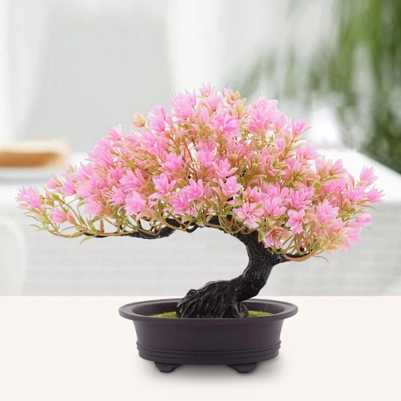 Small artificial bonsai tree with pink blossoms, dark textured trunk, in black pot