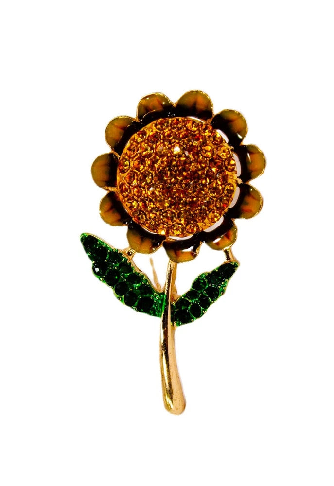 Sunflower brooch pin with golden-orange crystal center, green enamel leaves, gold-tone pin