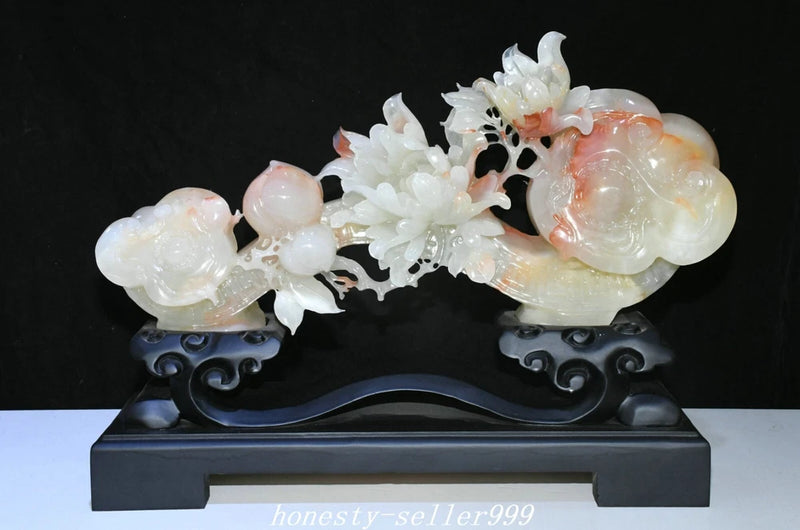 Carved jade peony and ruyi statue with white blossoms and peach-toned figure on black base
