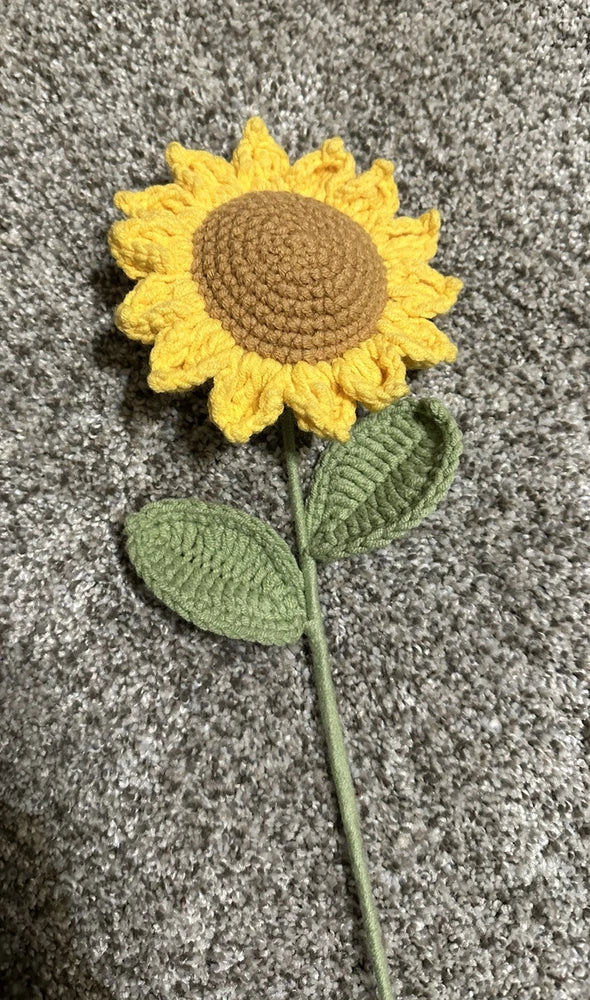Crochet artificial wool sunflower with yellow petals, green leaves, and stem