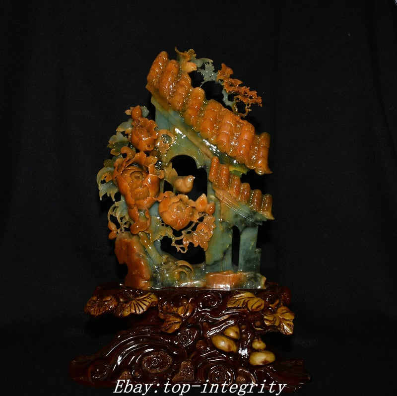 Carved decorative statue with bird and floral motifs, orange-brown and green accents