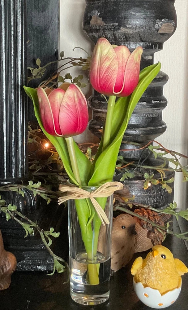 Pink tulip stems in clear glass vase